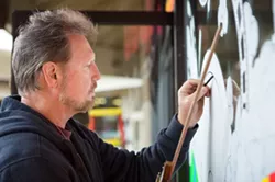 FROSTY FRONT: During the holidays, window painter Mike Loney likes to challenge himself with new takes on typical, seasonal standbys, like this festive snowman (below). - PHOTO BY KAORI FUNAHASHI