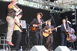 EVERYBODY JUMP!:  Emcee Joe Craven (left) jumps for joy while sitting in with Frank Vignola&rsquo;s Hot Club on the main stage. - PHOTO BY GLEN STARKEY