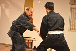 EMPOWERMENT: Jim Risinger goes blow-for-blow with a student. He and sensei Kenshin “Neil” Miyamoto teach tai chi, karate, and ninjitsu - at the Rising Sun Martial Arts Academy in Santa Maria. - PHOTO BY DAVID MINSKY
