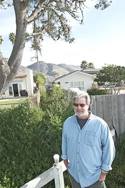 FENCES, NEIGHBORS : Tim Page of the citizen group Save Our Access Path stands in front of homeowner Mark Yandow’s house. The two are working on a settlement to reopen a long-closed path to the beach. - FILE PHOTO