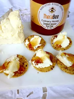 AN APP FOR THAT: Easy holiday appetizers are a breeze with TheraBee Culinary Honey’s Smoked Tomato Thai Chile speared over a - dollop of cream cheese. This is one local gift you may want to purchase for yourself, too. Yes, it’s that good. - PHOTO COURTESY OF THERABEE HONEY
