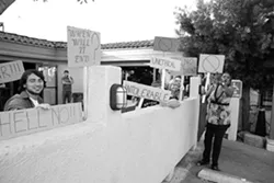 VAGUE PROTEST, FINAL SCENE : The vague protest flash mob concluded at McCarthy’s where we handed off our signs to a new generation of protestors. - PHOTO BY STEVE E. MILLER