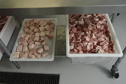 4: : The tray on the left is pancetta for the Buona Tavola restaurants and the tray on the right is shoulder and leg meat that will be used in the salami production.