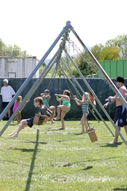 SWINGERS : Kids were everywhere, swinging, climbing, and tumbling through the grassy playground area by the pool. - PHOTO BY GLEN STARKEY