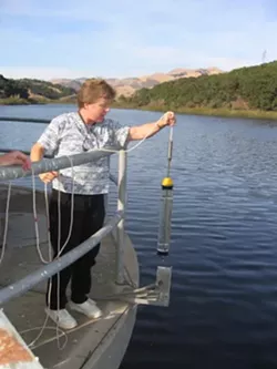 TESTING THE WATERS : Lopez Lake water spends 30 days in the terminal reservoir off Orcutt Road, where Water Systems Chemist Lisa Wallender grabs samples at various depths. - PHOTO BY KATHY JOHNSTON