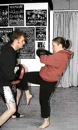ALL'S FAIR IN LOVE AND KICKBOXING : My boyfriend Peter and I often work out together and hold protective pads for each other during our Muay Thai classes at the Budo-Ryu School of Martial Arts in San Luis Obispo. The proper technique for landing a knee punch is using momentum from your hips to push the knee out, rather than bringing it straight up, at your opponent. - PHOTO BY ERIC SANDAHL