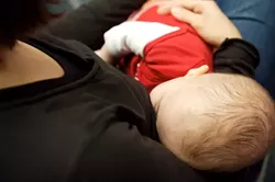 MEALTIME : Kiki Jouet, six months old, satisfied her hunger at a recent La Leche League of San Luis Obispo meeting. Attendees including Kikis mom, Lisa shared stories about how friendly the city and county are toward breastfeeding mothers. - PHOTO BY JESSE ACOSTA