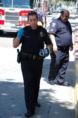 POLICEMAN HOLDS FALLEN VICTIM’S SHOE: - COURTESY: NICK KOURY