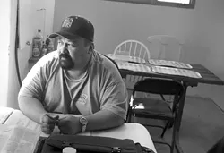 MAKING IT ADD UP : Jesse does the books for Sunny Acres and is one of the few residents who is going to be allowed to stay. - CHRISTOPHER GARDNER