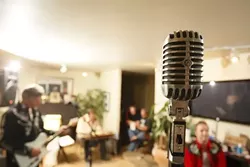 OLD SCHOOL : Singer Paul Brown belts out the band's tunes on a vintage-looking microphone, all part of the band's tightly controlled image. - PHOTO BY STEVE E. MILLER