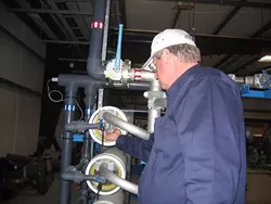 DESALINATION TECHNOLOGY : Morro Bay's capital projects manager Bill Boucher examines the reverse-osmosis membranes used along with huge amounts of electricity to remove salt from seawater at the Morro Bay desalination plant. - PHOTO BY KATHY JOHNSTON