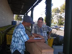 PLEASE SIGN HERE : San Luis Obispo resident Terry Mohan (right) is fighting water rate hikes the old-fashioned way, with an initiative petition. Walter Shipp (left) said he signed it to protest higher water bills. - PHOTO BY KATHY JOHNSTON