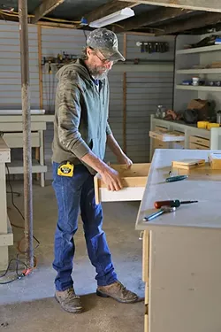 BUILDING HOME: Sunny Acres resident David Dieter has a background in the cabinet industry. Since he arrived at the facility four months ago, he’s remodeled the wood shop. Dieter said he’s battled alcoholism in his life, but because he’s got so much to do at Sunny Acres, he hasn’t been drinking. The sober living facility is in the process of trying to get its zoning changed so more people can get off the streets and into a bed on the property. - PHOTO BY DYLAN HONEA-BAUMANN