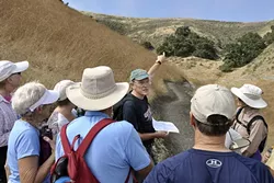 OVER THERE: Land Conservancy board member at large Randy Knight points to the ridgeline, describing some of the trails farther inland from the Pacific Ocean. - PHOTO BY CAMILLIA LANHAM