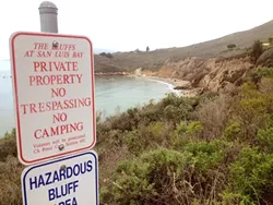 KEEP OUT: The California Coastal Commission sent a stern letter of warning to the city of Pismo Beach over these signs, which they say could discourage public access to the bluffs and trails near Pirate’s Cove. - PHOTO BY CHRIS MCGUINNESS