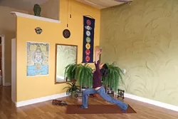 LET IT FLOW: Silvia Suarez, new owner of the Holistic Movement Center in Morro Bay, demonstrates the warrior one yoga posture. Silvia won the studio through a contest and officially took over in January. - PHOTO BY DYLAN HONEA-BAUMANN