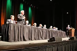 FIRED UP: Cal Poly hosted the first major debate among candidates vying for the vacant seat representing California’s 24th Congressional District. Candidates, from left to right: Justin Fareed, William Ostrander (standing), John Uebersax, Katcho Achadjian, Salud Carbajal, Steve Isakson, Matt Kokkonen, Helene Schneider, and Jeff Oshins. KCBX-FM News Director Randol White, far right, moderated the event. - PHOTO BY DYLAN HONEA-BAUMANN