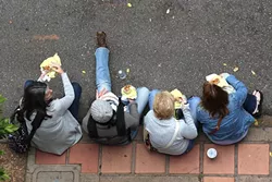 STREET GRUBBIN’: The curb is as good a place as any to dine during Downtown SLO Farmers’ Market. - PHOTO BY DYLAN HONEA-BAUMANN