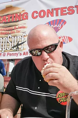 THE CHAMP!: Daniel “Doughboy” Arndt put away 7 3/4 plate-size pancakes in four minutes to win the seventh annual Pancake Eating Contest at Penny’s All American Café to benefit AmpSurf. - PHOTO BY GLEN STARKEY