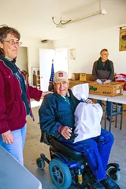 A LITTLE SECURITY: A man named Bendo receives a bag of food from Tensie Hernandez at the Catholic Worker in Guadalupe. - PHOTO BY JAYSON MELLOM