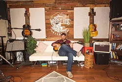 MAN CAVE DELUXE: Moonshiner Collective frontman Dan Curcio kicks back in his plush South County home recording studio. - PHOTO BY JAYSON MELLOM