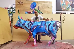 A COW OF A DIFFERENT COLOR: Artist Man One stands with a cow he painted for the public art show, COWABUNGA, in Dana Point, Calif. Man One will paint another cow live for the Cow Parade in SLO on Sept. 17. - PHOTO COURTESY OF MAN ONE