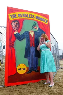 PRETTY AS A CARNIVAL PICTURE: Anna Starkey got all dolled up in ’40s garb, posing here with one of the many props scattered along the beach raceway. - PHOTO BY GLEN STARKEY