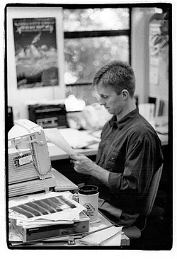 WORKING HARD?: A young Steven T. Jones looks over a document at his 'New Times' desk. - FILE PHOTO