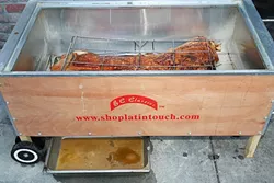 THIS ‘LITTLE’ PIGGIE: Granada Hotel and Bistro is rolling out a whole pig each week to share with hungry folks at the downtown SLO Thursday Farmers’ Market. A meaty Berkshire hog is roasted for 10 hours in a Cuban Caja China barbecue box. - PHOTO BY DYLAN HONEA-BAUMANN