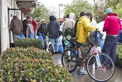 INCREASED NEED: Around 5:30 p.m. on Feb. 17, about 20 people waited to check in to the 5 Cities Homeless Coalition’s emergency shelter on Grand Avenue in Arroyo Grande. One volunteer said they were waiting for a bus to drop off more people later that evening. It’s already served five times more shelter nights than it did all of last winter. - PHOTO BY JAYSON MELLOM
