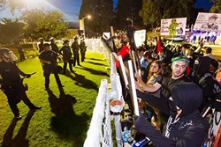 STAND OFF: Protesters outside the Spanos Theater at Cal Poly demonstrate against right-wing activist Milo Yiannopoulos on Jan. 31, held off by a heavy law enforcement presence. - PHOTO BY JAYSON MELLOM