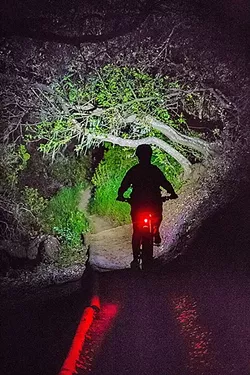 TWILIGHT RIDE : Christie O’Hara rides her mountain bike at Irish Hills Natural Reserve shortly after sunset. - PHOTO BY JAYSON MELLOM