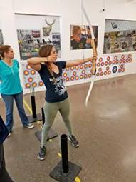 LET IT GO Seconds after releasing my arrow, my hand fights to stay glued to my face rather than moving forward and throwing off my arrow's aim during an adult archery class at Central Coast Archery in SLO. - PHOTO COURTESY OF RYAH COOLEY