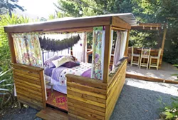 COUNTRY LIVING Finny and Stacy Smith's 40-acre lavender farm near Avila Beach features a variety of outdoor living areas including this outdoor bedroom decorated with drying lavender as well as the outdoor kitchen behind it. - PHOTO BY JAYSON MELLOM