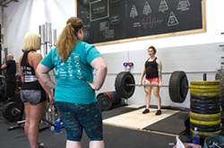 PUSHING YOURSELF At 31 weeks pregnant in June, Brandy French, far right, still takes part in SLO Strong workouts, pictured here lifting 225 pounds. - PHOTO BY JAYSON MELLOM