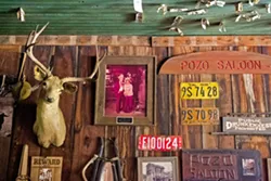 DOLLAR BILLS AND BULLET HOLES? Dozens of dollar bills have been pinned to the saloon ceiling by patrons, and some speculate that Wild West-era bullets left holes up there. - PHOTO BY JAYSON MELLOM
