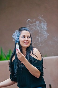 WITCHY WOMAN Shelby Bundy, owner of Tamed Wild Apothecary in Arroyo Grande, demonstrates how to sage and purify oneself during a full moon ritual. - PHOTO BY JAYSON MELLOM