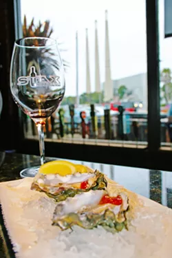 ON THE HALF SHELL Oysters on the half shell, local wine, and a beachy view? This is real life at Stax Wine Bar in Morro Bay. Owned by Giovanni DeGarimore of Giovanni's Fish Market & Galley, Stax is able to offer up fresh seafood whenever a good catch is hauled in from the bay. - PHOTO COURTESY OF REID CAIN