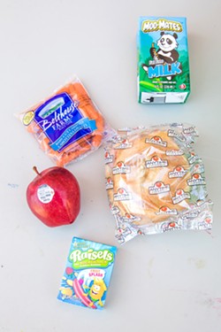 NOT SO STANDARD Participants of the summer meal program can count on not only a snack in their white paper sack but an apple, carrots, a sandwich, and milk. - PHOTO BY JAYSON MELLOM
