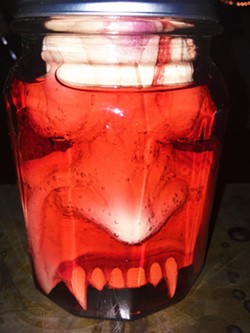 WTF? A weird jar full of face sits on the bar at Tooth and Nail winery. - PHOTO BY CAMILLIA LANHAM