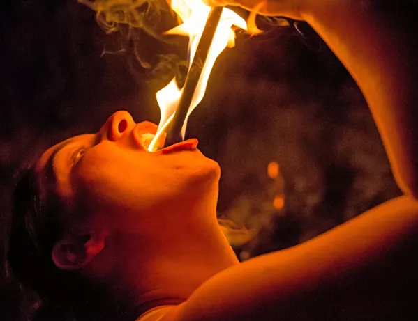 EAT IT Sword-swallower Samantha Jones sticks a fire wand in her mouth. Getting burned is inevitable, she said—it’s just a matter of degree. - PHOTO BY JAYSON MELLOM