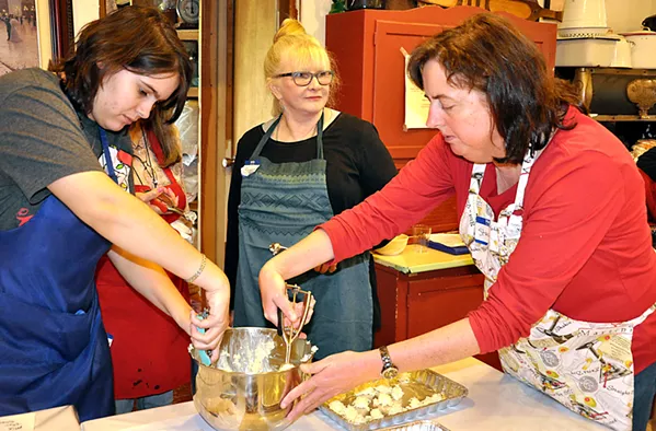COCONUTS Sheree Garcia (left) and Stacey Bassett (right) scoop coconut and white chocolate into round balls as Jasmyn Carpenter checks out the turtle bark demo happening at the next table over. - PHOTOS BY CAMILLIA LANHAM