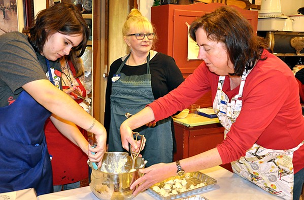 COCONUTS Sheree Garcia (left) and Stacey Bassett (right) scoop coconut and white chocolate into round balls as Jasmyn Carpenter checks out the turtle bark demo happening at the next table over. - PHOTOS BY CAMILLIA LANHAM
