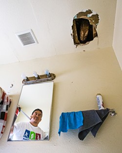 UNCOMFORTABLE In one unit of the Grand View Apartments in Paso Robles, a gaping hole above the bathroom sink often spills debris. - PHOTOS BY JAYSON MELLOM