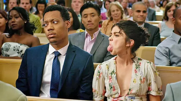 LOVE AND MARRIAGE Committment-phobe Mara Hickey (Sarah Hyland, right) finds her relationship with boyfriend Jake Riddick (Tyler James Williams) tested when they're invited to multiple weddings over the course of a year, in The Wedding Year. - PHOTO COURTESY OF LAKESHORE ENTERTAINMENT