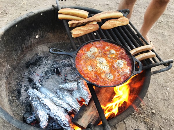 FIRE My friend likes to go all-out on cooking when he camps. So we made shakshuka and grilled corn and sausages after a rather absurdly elaborate grocery shopping trip. - PHOTOS BY PETER JOHNSON