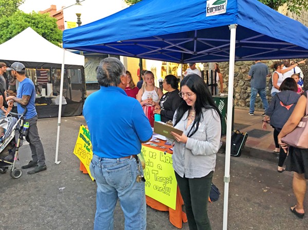 SURVEY TIME One of the Close to Home committee's first steps was to design a survey to try to understand how San Luis Obispo residents view violence in their community. Committee members staff a table at the downtown SLO Farmers' Market. - PHOTO COURTESY OF JANAE SARGENT