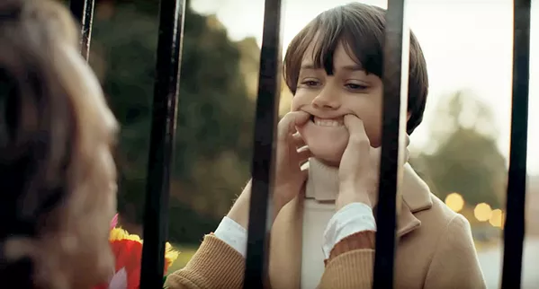TURN THAT FROWN UPSIDE DOWN Arthur Fleck (Joaquin Phoenix, left) meets the young Bruce Wayne (Dante Pereira-Olson) for the first time through the gate at Wayne Mansion. - PHOTOS COURTESY OF BRON STUDIOS