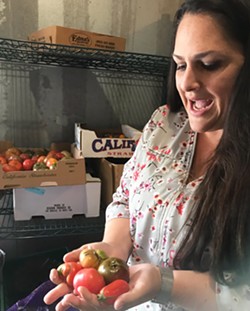 HEIRLOOMS FOR YOUNG FOODIES Director of Food Services for San Luis Coastal Erin Primer holds up some fresh heirloom tomatoes from a local farm for the schools' cafeteria salad bar. What she hears all the time: "This is the best tomato I've ever had!" - PHOTO BY BETH GIUFFRE
