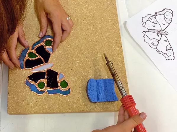 TAKE FLIGHT A class participant at Glasshead Studio makes a mosaic butterfly. - PHOTO COURTESY OF LISA RENÉE FALK